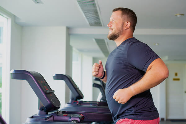 EXUDE FITNESS AVERAGE MAN RUNNING ON TREADMILL AT THE GYM